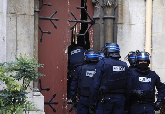 French police officers storm a church after a raid in Paris suburb Saint-Denis, Wednesday, Nov.18, 2015.  A woman wearing an explosive suicide vest blew herself up Wednesday as heavily armed police tried to storm a suburban Paris apartment where the suspected mastermind of last week's attacks was believed to be holed up, police said. (ANSA/AP Photo/Thibault Camus)