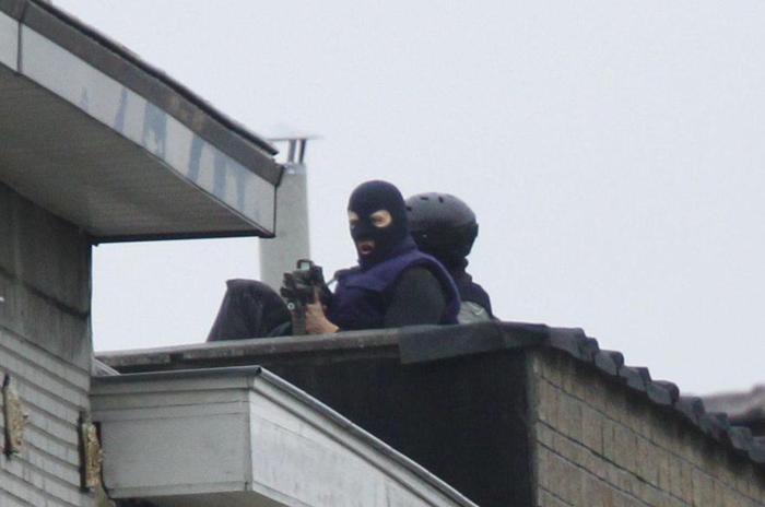 epa05028126 Snipers stand  at rue Delaunoy in the streets of Molenbeek, Brussels, Belgium, 16 November 2015. More than 130 people were killed and hundreds injured in the terror attacks which targeted the Bataclan concert hall, the Stade de France national sports stadium, and several restaurants and bars in the French capital on 13 November. Authorities believe that three coordinated teams of terrorists armed with rifles and explosive vests carried out the attacks, which the Islamic State (IS) extremist group has claimed responsibility for.  EPA/OLIVIER HOSLET