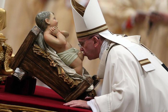 Pope Francis kisses a baby Jesus statue as he leads the midndight Christmas Mass in Saint Peters Basilica at the Vatican late  24 December 2014.
ANSA/ALESSANDRO DI MEO