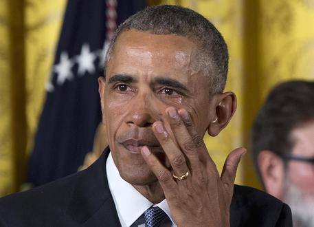 President Barack Obama wipes away tears from his eyes as he speaks in the East Room of the White House in Washington, Tuesday, Jan. 5, 2016, about steps his administration is taking to reduce gun violence. Also on stage are stakeholders, and individuals whose lives have been impacted by the gun violence. (ANSA/AP Photo/Carolyn Kaster)