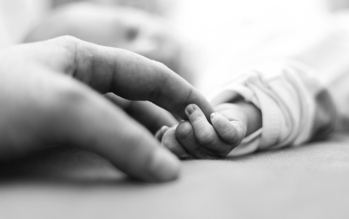 Baby is holding father's finger for the first time