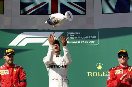 Second placed Ferrari driver Sebastian Vettel of Germany, race winner Mercedes driver Lewis Hamilton of Britain and Ferrari driver Kimi Raikkonen of Finland, from left to right, celebrate on the podium of the Hungarian Formula One Grand Prix, at the Hungaroring racetrack in Mogyorod, northeast of Budapest, Sunday, July 29, 2018. (ANSA/AP Photo/Laszlo Balogh) [CopyrightNotice: Copyright 2018 The Associated Press. All rights reserved]