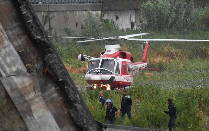 Rescuers at the site of the collapsed bridge in Genoa, Italy, 14 August 2018. A large section of the Morandi viaduct upon which the A10 motorway runs collapsed in Genoa on Tuesday. Both sides of the highway fell. Around 10 vehicles are involved in the collapse, rescue sources said Tuesday. The viaduct gave way amid torrential rain. The viaduct runs over shopping centres, factories, some homes, the Genoa-Milan railway line and the Polcevera river. ANSA/LUCA ZENNARO