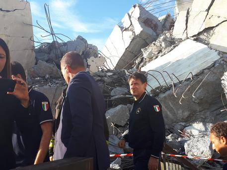 Il premier Giuseppe Conte al termine del sopralluogo tra le macerie del Ponte Morandi, Genova, 14 agosto 2018. ANSA/MATTEO GUIDELLI
