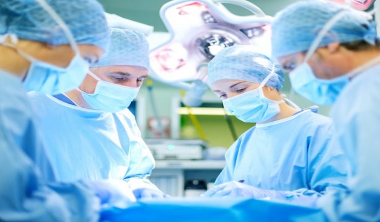Surgeons Operating Patient In Hospital Theater