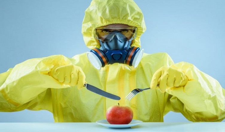 Man wearing protective clothes with red apple. GMO or poisonous food concept.