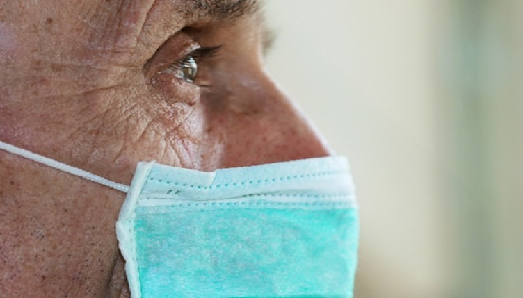 face of elderly man wearing medical facemask