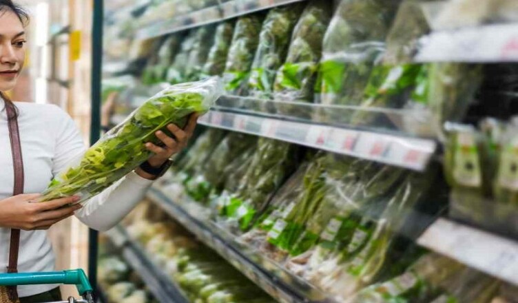 young asian woman choosing vegetables while shopping food in supermarket