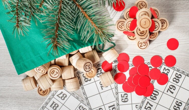 Board game lotto. Wooden lotto barrels with bag, game cards and red chips for a game in lotto, Christmas fir tree branches. Top view